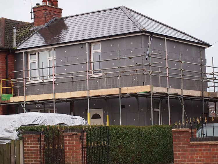 House fully boarded with EWI insulation on scaffolding